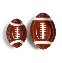Load image into Gallery viewer, Two football-shaped ceramic dishes in different sizes, featuring a glossy brown body with white stripes and laces, set against a plain white background.