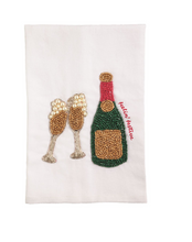 Load image into Gallery viewer, A white fabric napkin or tea towel featuring a beaded embroidery design of two clinking champagne flutes and a champagne bottle with a red foil top and the words 'Vivienne Vostre'.
